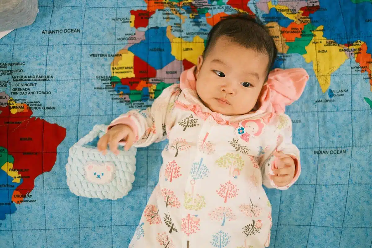 Smiling baby lying on a blanket with baby name blocks around, representing baby middle name ideas.