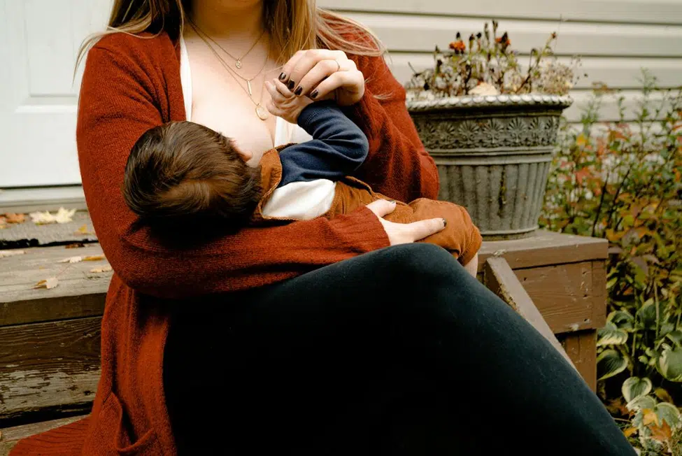 Breastfeeding supplements including vitamins, herbal capsules, and lactation teas arranged on a wooden table.