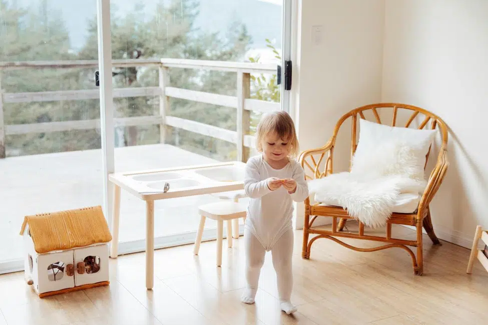Minimalist baby registry essentials including baby gym, muslin blanket, and neutral-toned baby items neatly arranged in a cozy nursery.