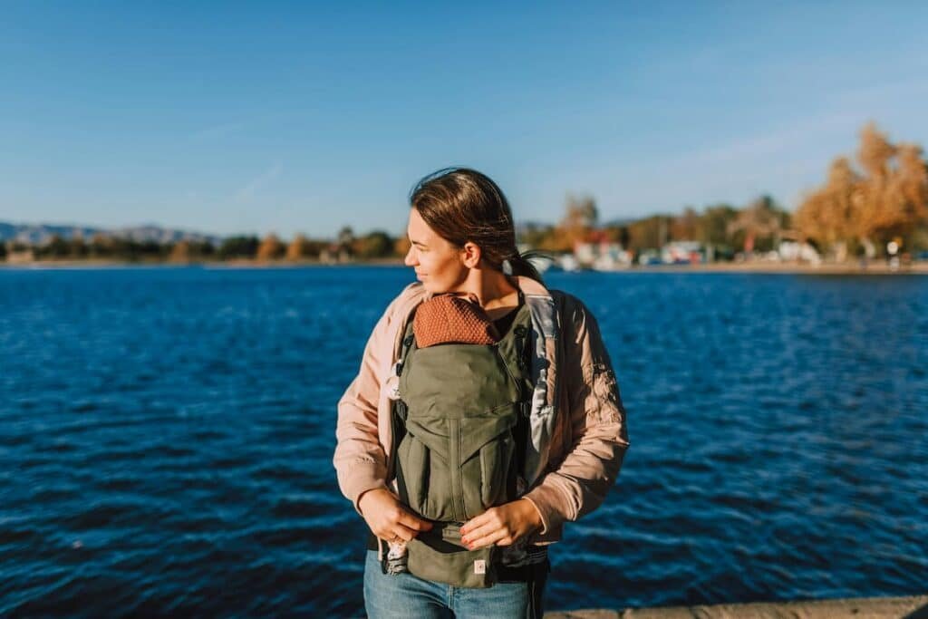 Plus size mom wearing a baby carrier in front carry position