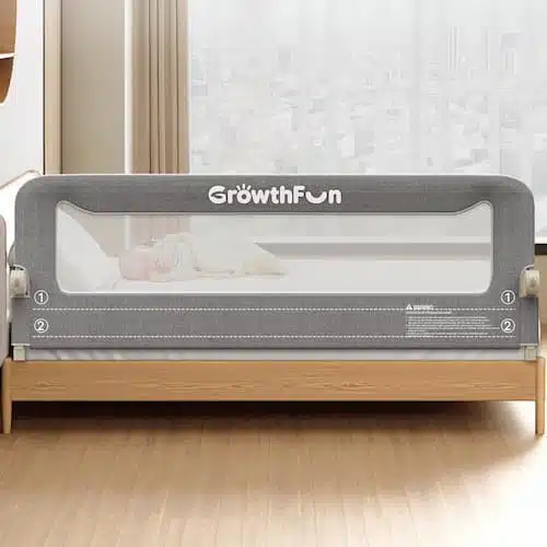 A 71-inch grey foldable bed rail for toddlers with a reinforced carbon steel frame and breathable cationic fabric, shown installed on a bed to prevent accidental falls.