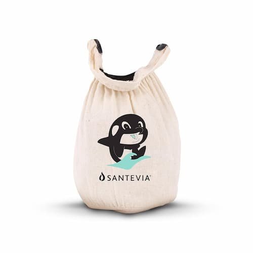 A cream-colored Santevia organic cotton pouch bath faucet filter with a cute killer whale illustration, hanging on a tub spout to purify bath water.
