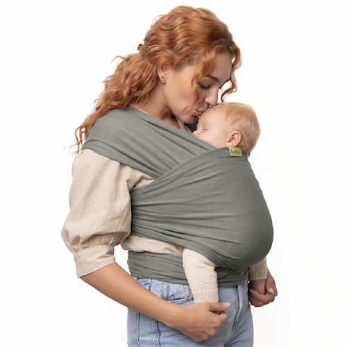 Boba baby wrap carrier in grey cotton holding a newborn baby in an ergonomic front chest position.